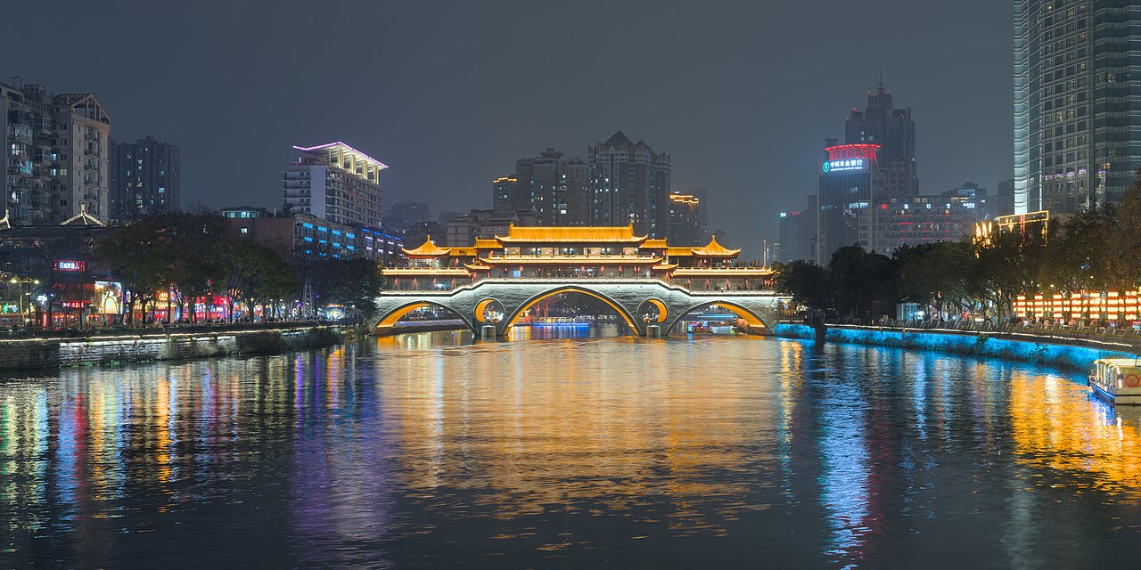 Illuminated Anshun Veranda Bridge reflecting in the Jin River at night in Chengdu
