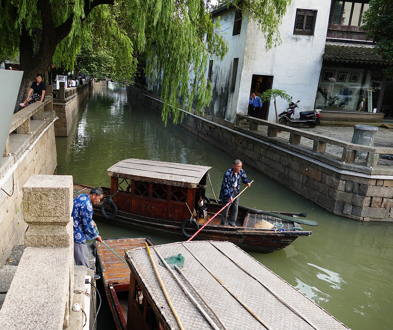 Traditional wooden boats and stone bridges along a historic canal in Suzhou near Shanghai